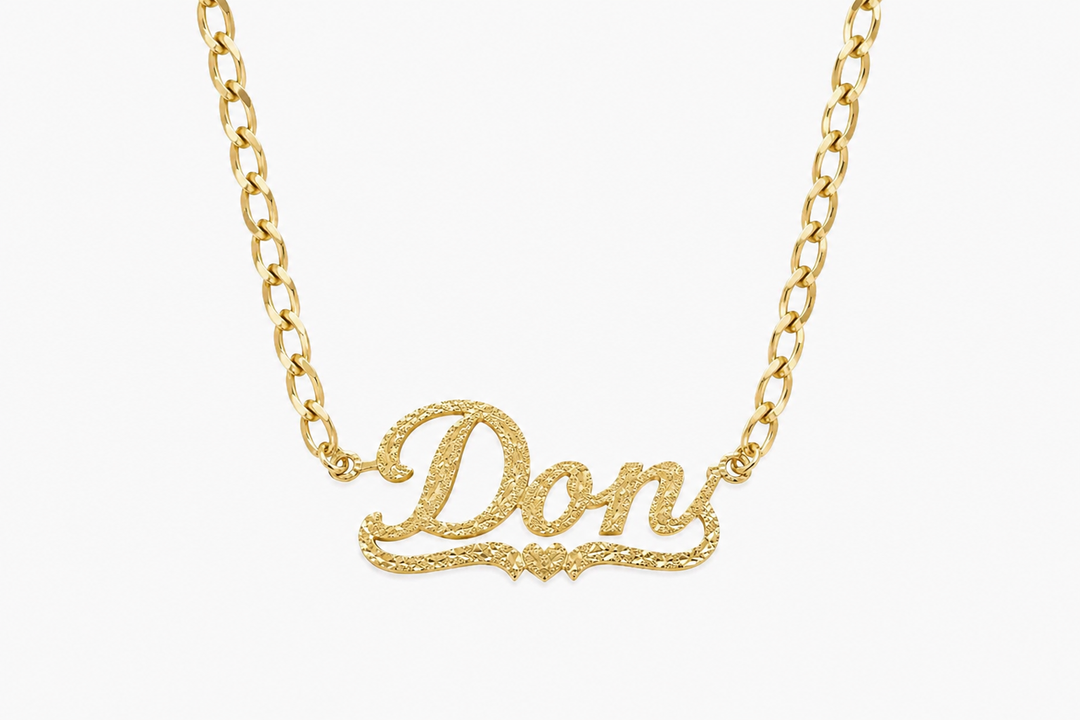 Custom gold diamond-cut name necklace in script font on a Cuban link chain